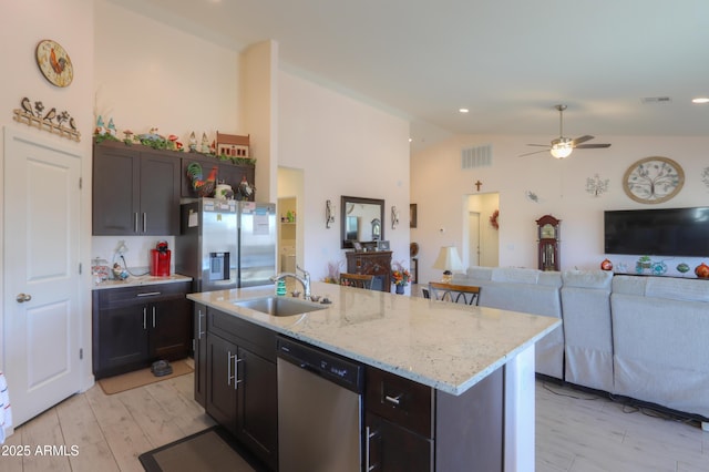 kitchen with a sink, visible vents, open floor plan, appliances with stainless steel finishes, and an island with sink