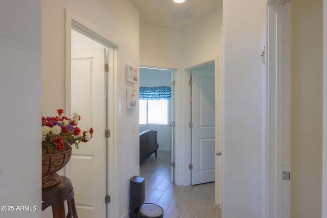 corridor featuring light wood finished floors and visible vents