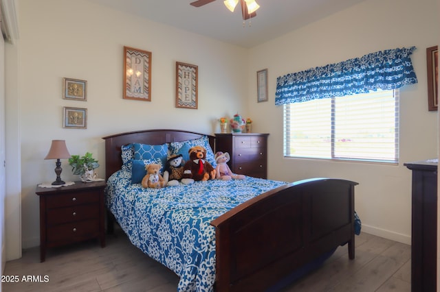 bedroom featuring baseboards, a ceiling fan, and light wood-style floors