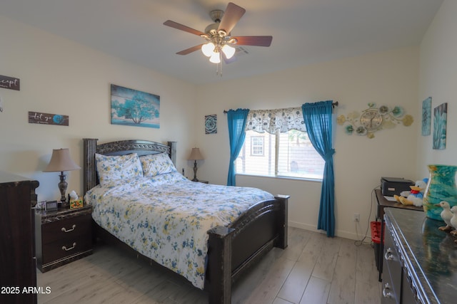 bedroom with light wood-type flooring, ceiling fan, and baseboards