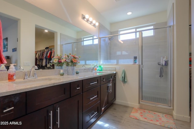 bathroom featuring a healthy amount of sunlight, a walk in closet, and a sink