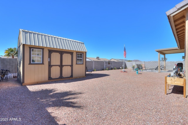 view of yard featuring a storage shed, a fenced backyard, and an outdoor structure