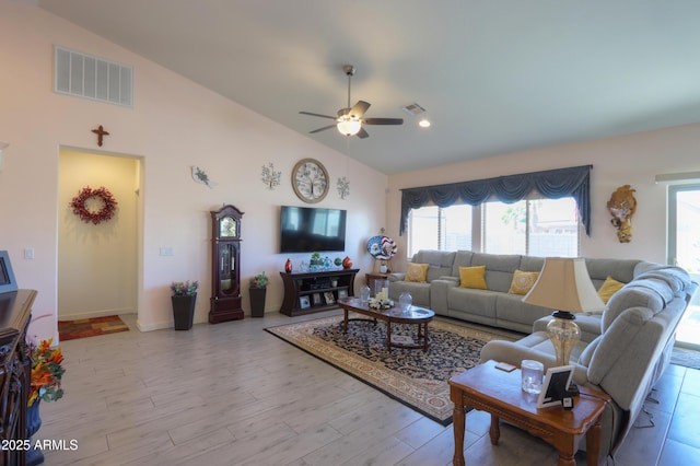 living room featuring high vaulted ceiling, light wood finished floors, visible vents, and a ceiling fan