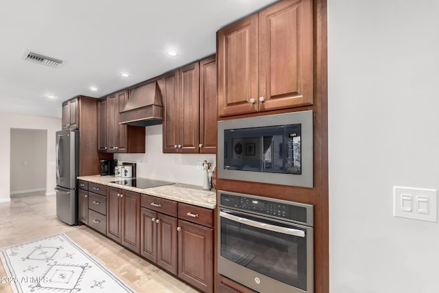 kitchen with premium range hood, light stone counters, and black appliances