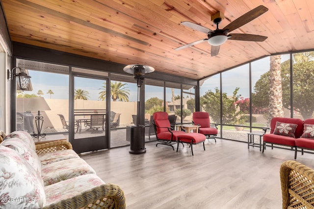 sunroom with ceiling fan, a wealth of natural light, and wood ceiling