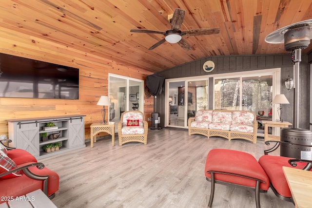 living room featuring ceiling fan, wood walls, vaulted ceiling, wood ceiling, and hardwood / wood-style flooring