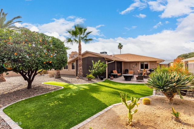 back of house featuring a yard, a patio, and a fire pit