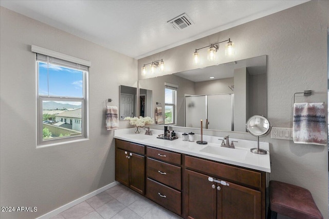 bathroom with tile patterned floors, vanity, and a shower with door