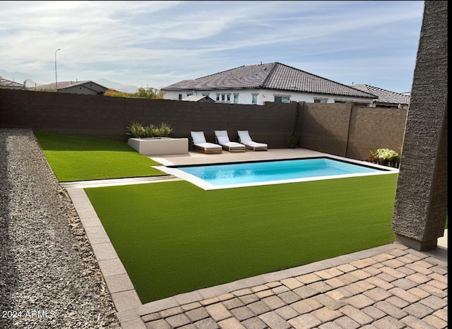 view of swimming pool with a patio area and a yard