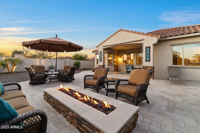 view of patio / terrace featuring fence and an outdoor living space with a fire pit