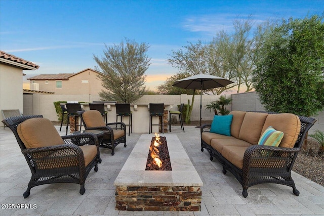 view of patio / terrace featuring outdoor dry bar, a fenced backyard, and an outdoor living space with a fire pit