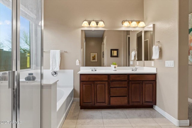 full bath featuring tile patterned floors, a garden tub, a sink, and double vanity