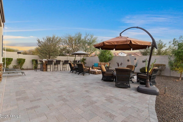 view of patio with an outdoor living space with a fire pit, a fenced backyard, and outdoor dry bar