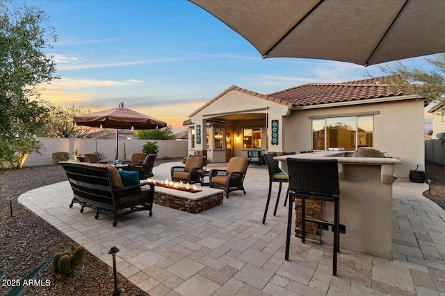 view of patio featuring an outdoor living space with a fire pit, fence, and outdoor dry bar