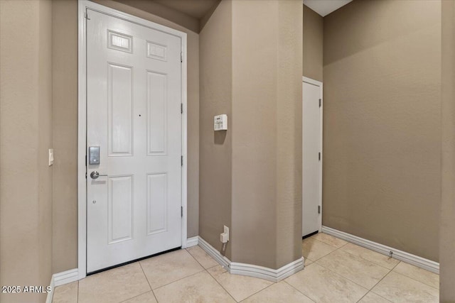 entryway featuring baseboards and light tile patterned floors