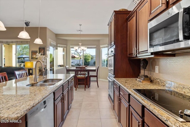 kitchen featuring stainless steel appliances, a wealth of natural light, a sink, and light tile patterned floors