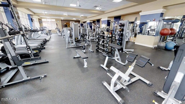 gym featuring a drop ceiling and baseboards