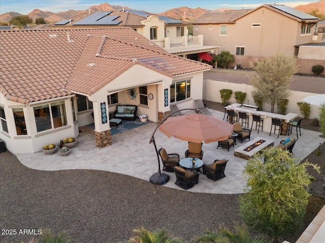 back of house with a fenced backyard, a patio area, a tile roof, and stucco siding