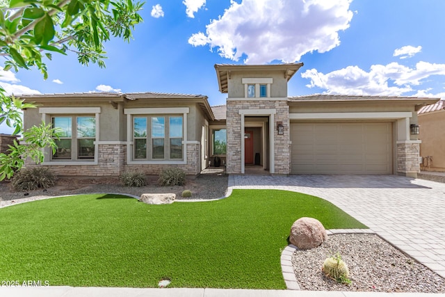 prairie-style home with stucco siding, stone siding, an attached garage, and decorative driveway