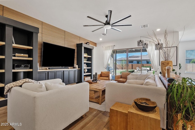 living area featuring wood finished floors, ceiling fan, healthy amount of natural light, and recessed lighting