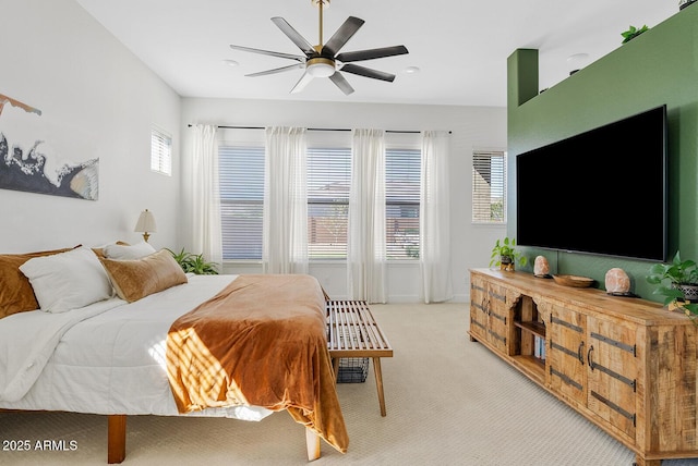 bedroom with light colored carpet and a ceiling fan