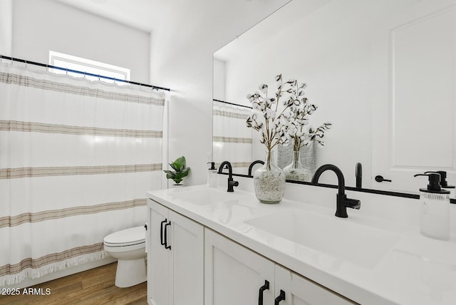full bathroom featuring toilet, wood finished floors, double vanity, and a shower with curtain
