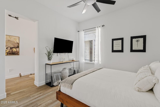 bedroom featuring wood finished floors, baseboards, and ceiling fan