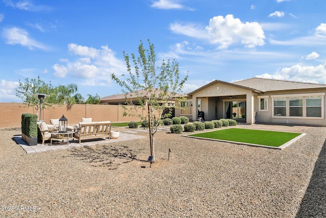 rear view of house with fence, a patio area, stucco siding, and an outdoor hangout area