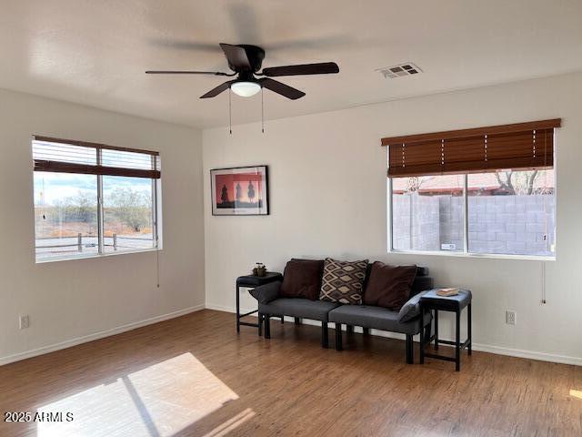 sitting room with wood-type flooring and ceiling fan