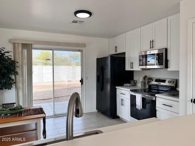 kitchen featuring white cabinetry, stainless steel appliances, sink, and light tile patterned floors