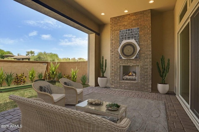 view of patio / terrace featuring an outdoor living space with a fireplace and fence