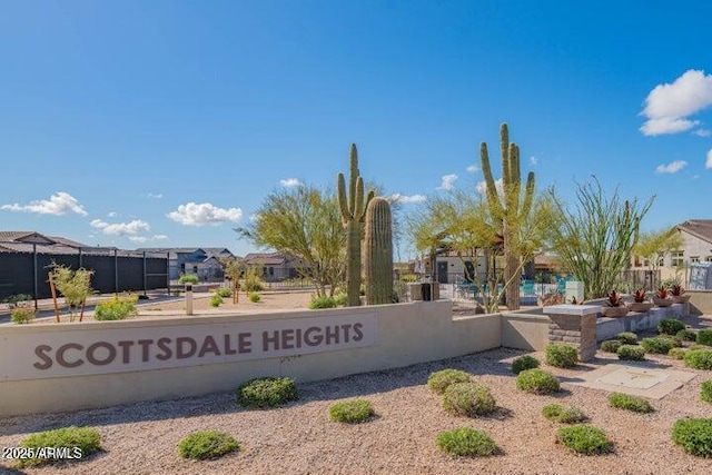 community / neighborhood sign featuring a residential view and fence