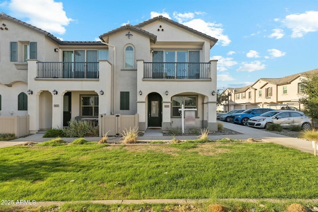 view of front of property featuring a balcony and a front yard