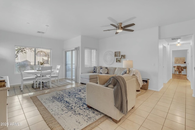 living area featuring ceiling fan, visible vents, baseboards, and light tile patterned flooring