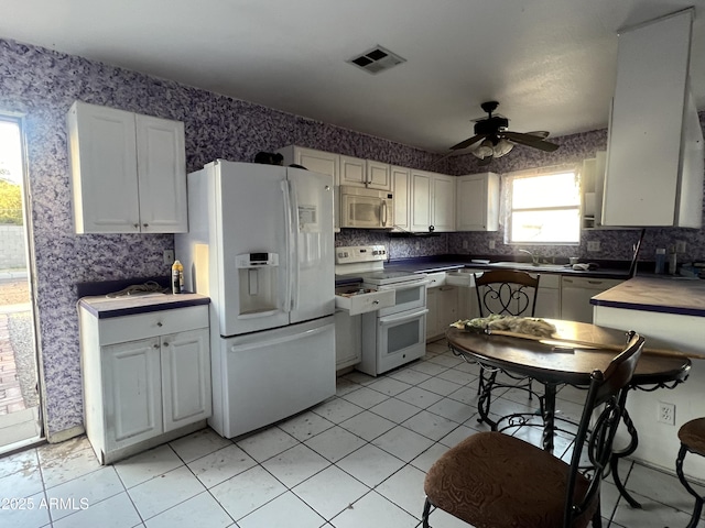 kitchen featuring ceiling fan, white cabinets, sink, and white appliances