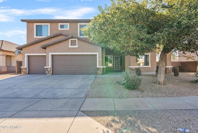 view of front of property with an attached garage, fence, driveway, stone siding, and stucco siding