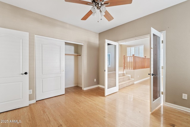 unfurnished bedroom with a closet, french doors, baseboards, and light wood finished floors