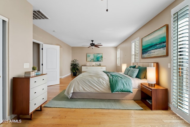 bedroom featuring light wood-type flooring, ceiling fan, and visible vents