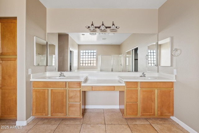 full bath featuring a stall shower, vanity, baseboards, and tile patterned floors