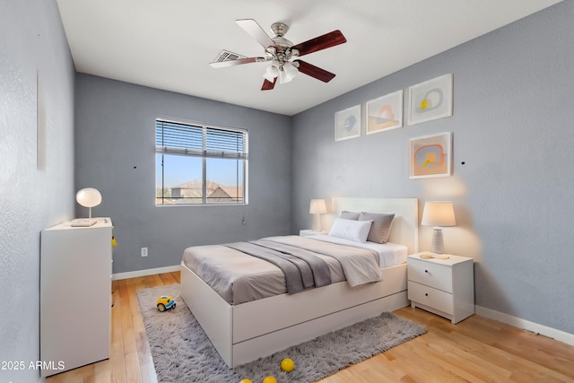 bedroom with visible vents, baseboards, ceiling fan, and wood finished floors