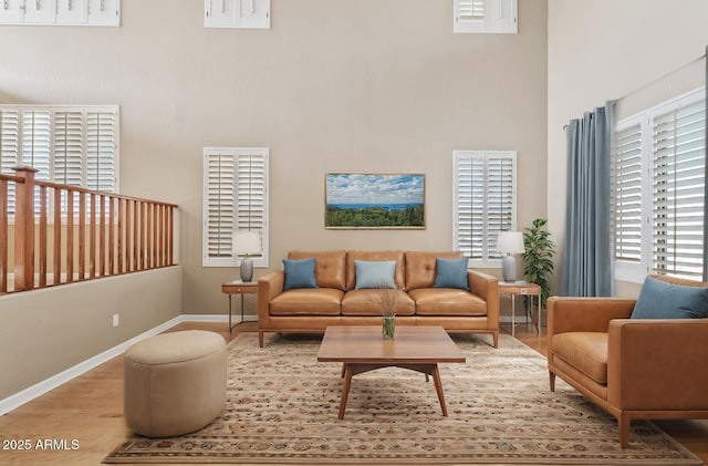 sitting room with a high ceiling, wood finished floors, and baseboards