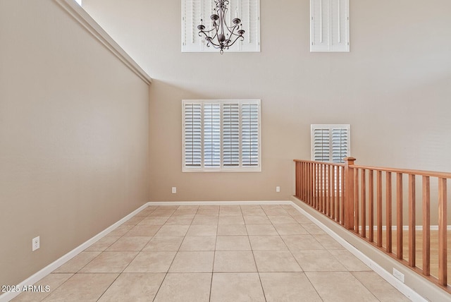 unfurnished room featuring an inviting chandelier, baseboards, and tile patterned floors