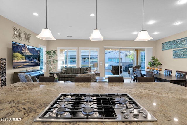 kitchen featuring light stone countertops, decorative light fixtures, and stainless steel gas cooktop