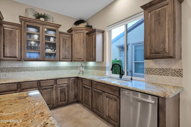 kitchen featuring dishwasher, tasteful backsplash, light stone counters, and sink