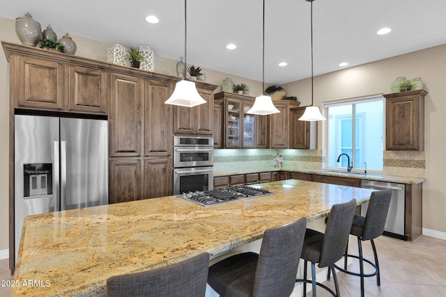 kitchen with a center island, backsplash, stainless steel appliances, and sink