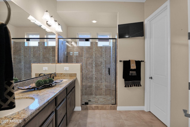 bathroom featuring vanity, tile patterned floors, a shower with shower door, and a healthy amount of sunlight