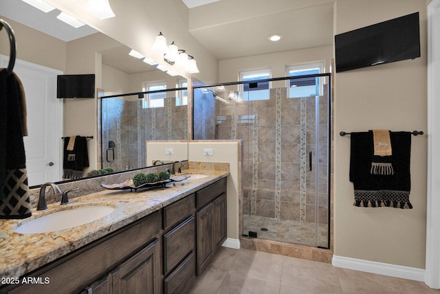 bathroom with tile patterned flooring, vanity, a shower with shower door, and a healthy amount of sunlight