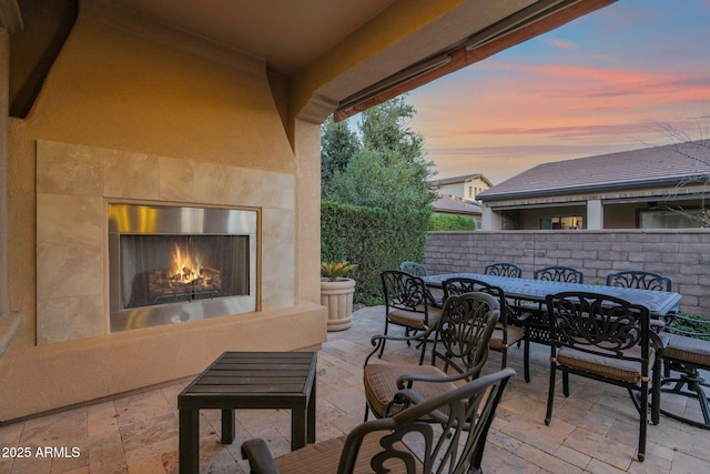 patio terrace at dusk with exterior fireplace