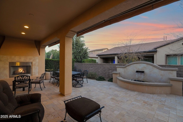 patio terrace at dusk with exterior fireplace