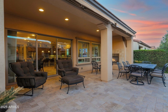 patio terrace at dusk with exterior fireplace